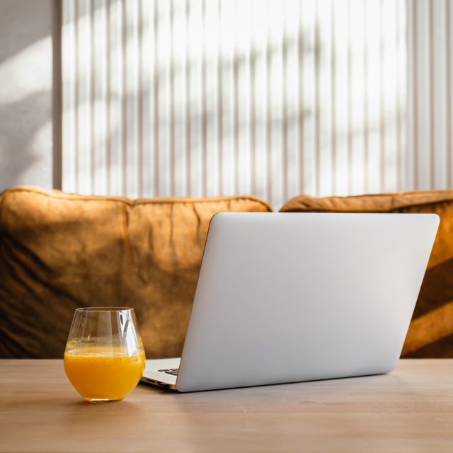 Verre de jus d'orange près d'un ordinateur